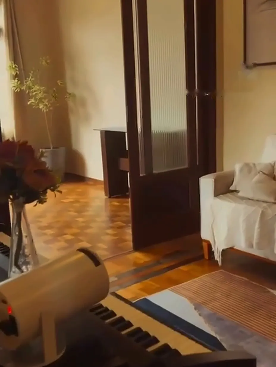 Recepção com piano, tapete e sofá.